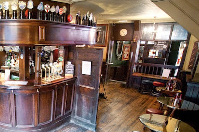 The curved, dark wood bar in Old Bell Tavern is unique.